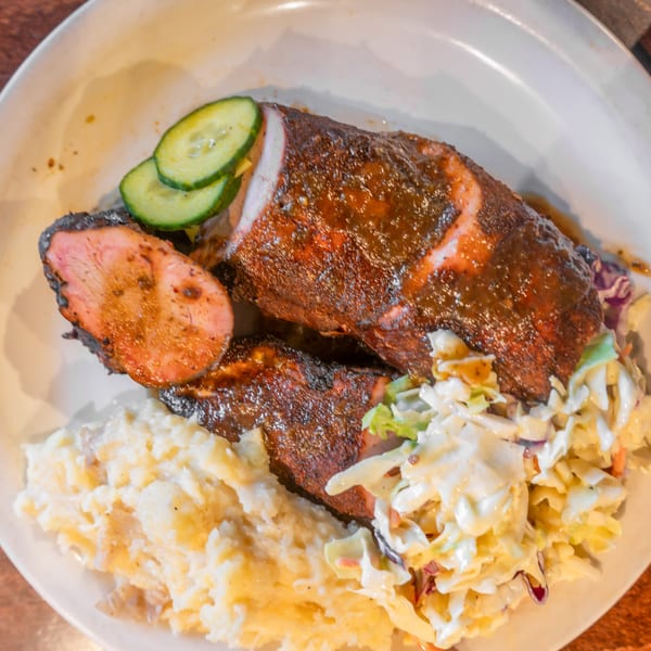 Flying Mango's BBQ pork tenderloin with mashed potatoes, coleslaw, and cucumber slices.