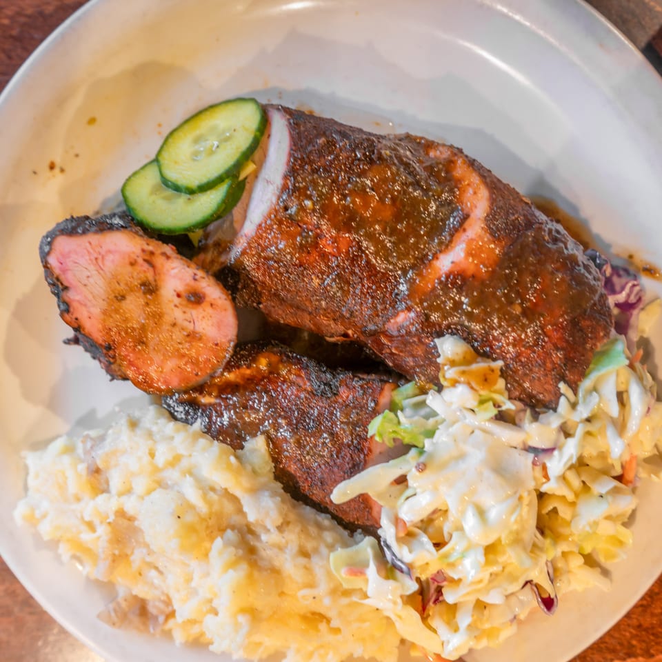 Flying Mango's BBQ pork tenderloin with mashed potatoes, coleslaw, and cucumber slices.